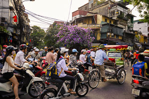 Une rue remplie de personnes voyageant en moto et scooter.
